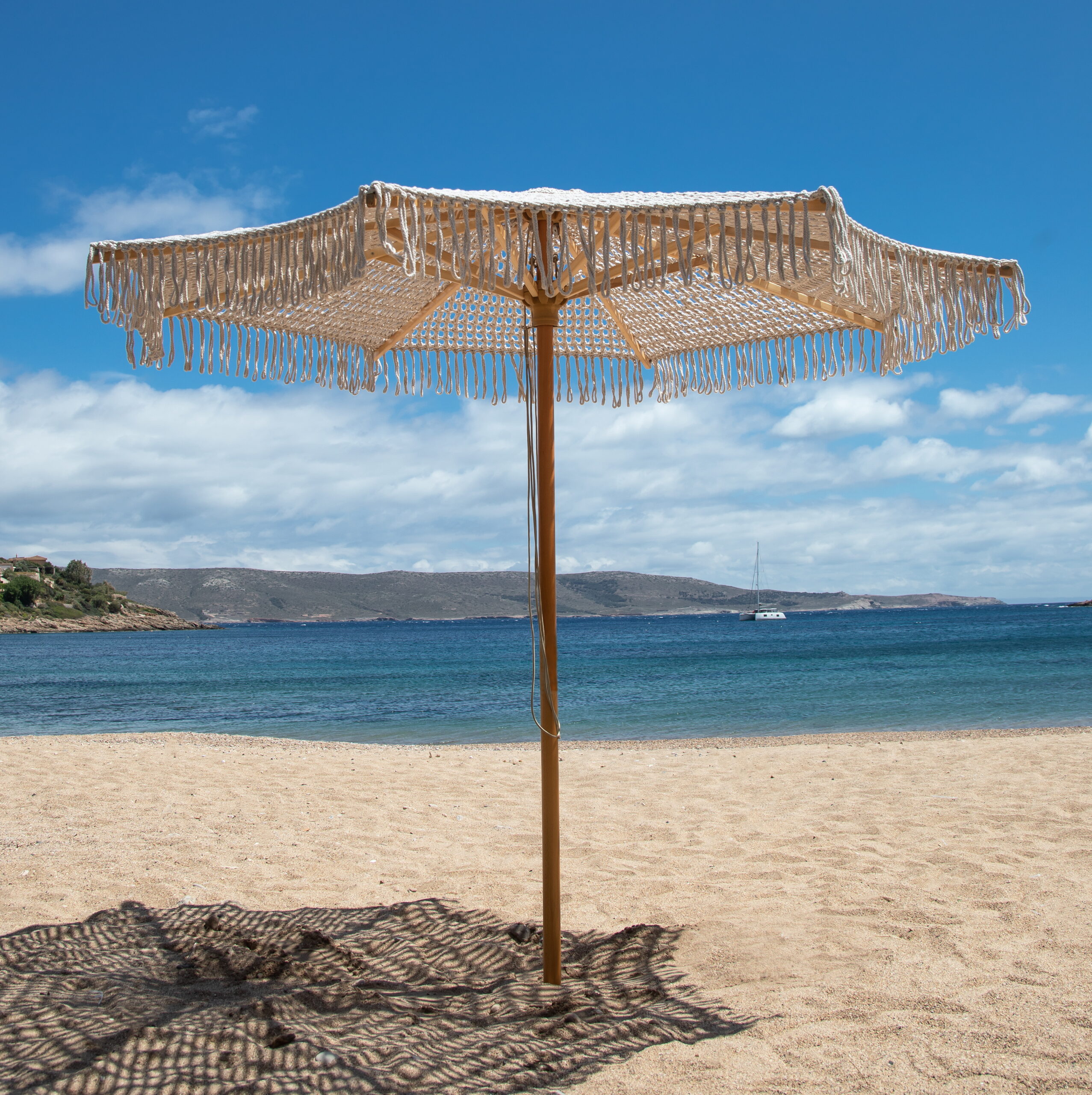 Ομπρέλα μακραμέ με φόντο παραλία